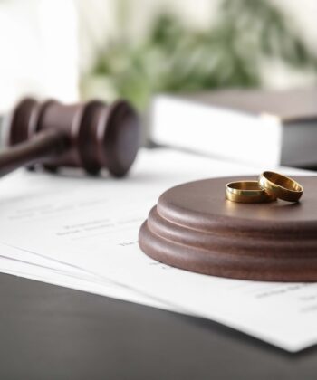 Rings-with-decree-of-divorce-and-judge-gavel-on-table